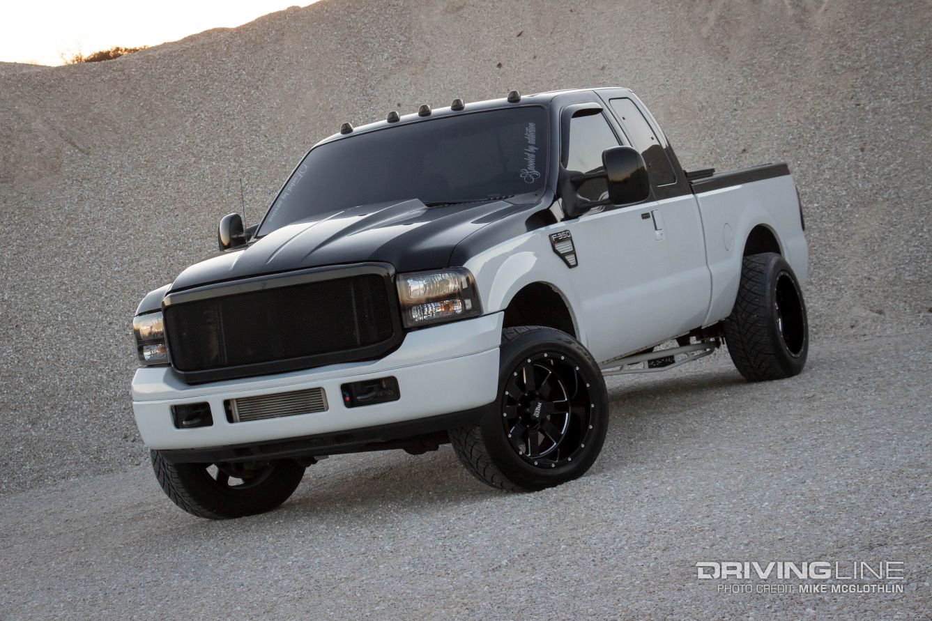 Black and white 2006 Ford F-350 with large wheels and tires
