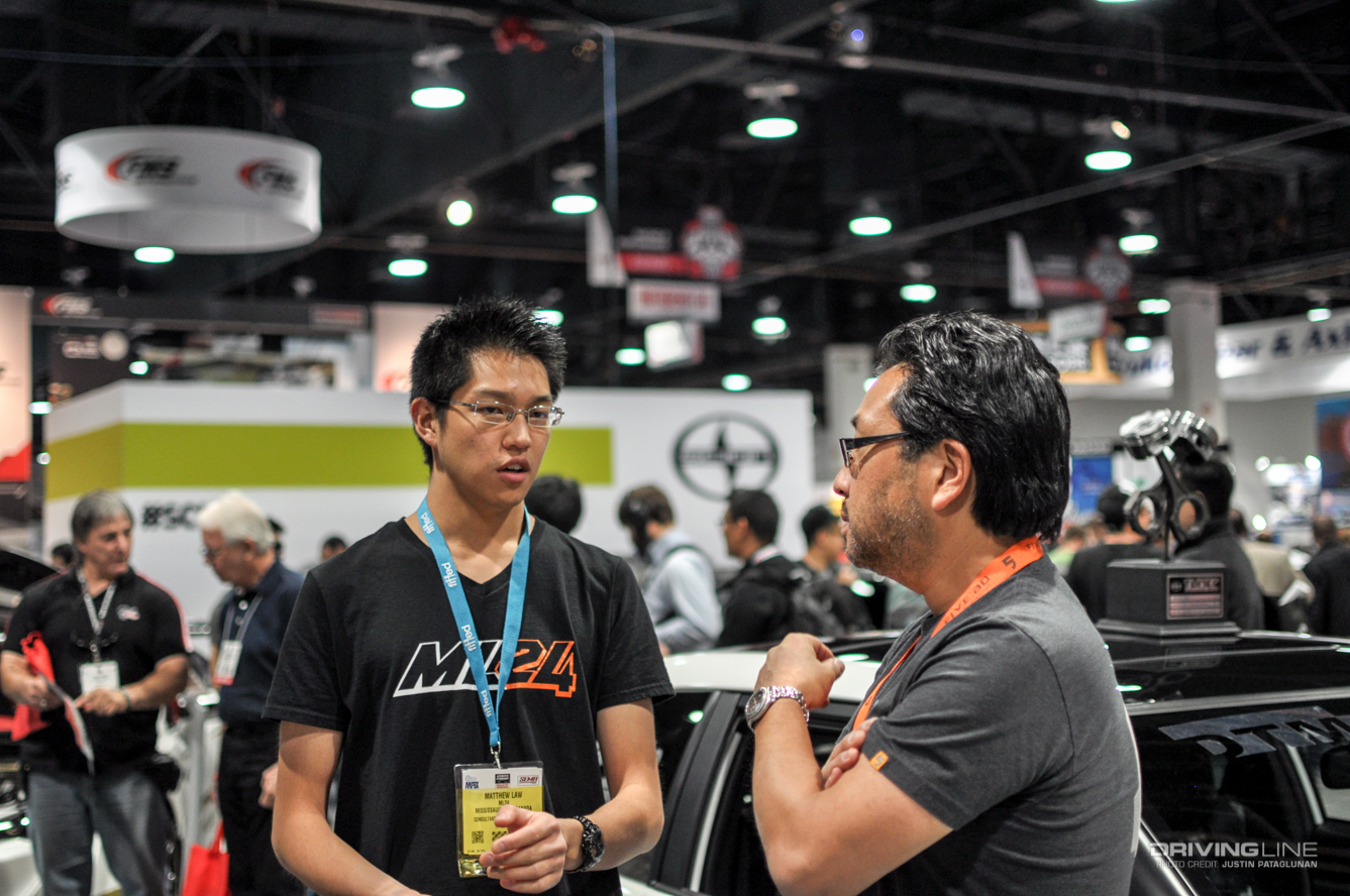 Two men talking at a car parts convention