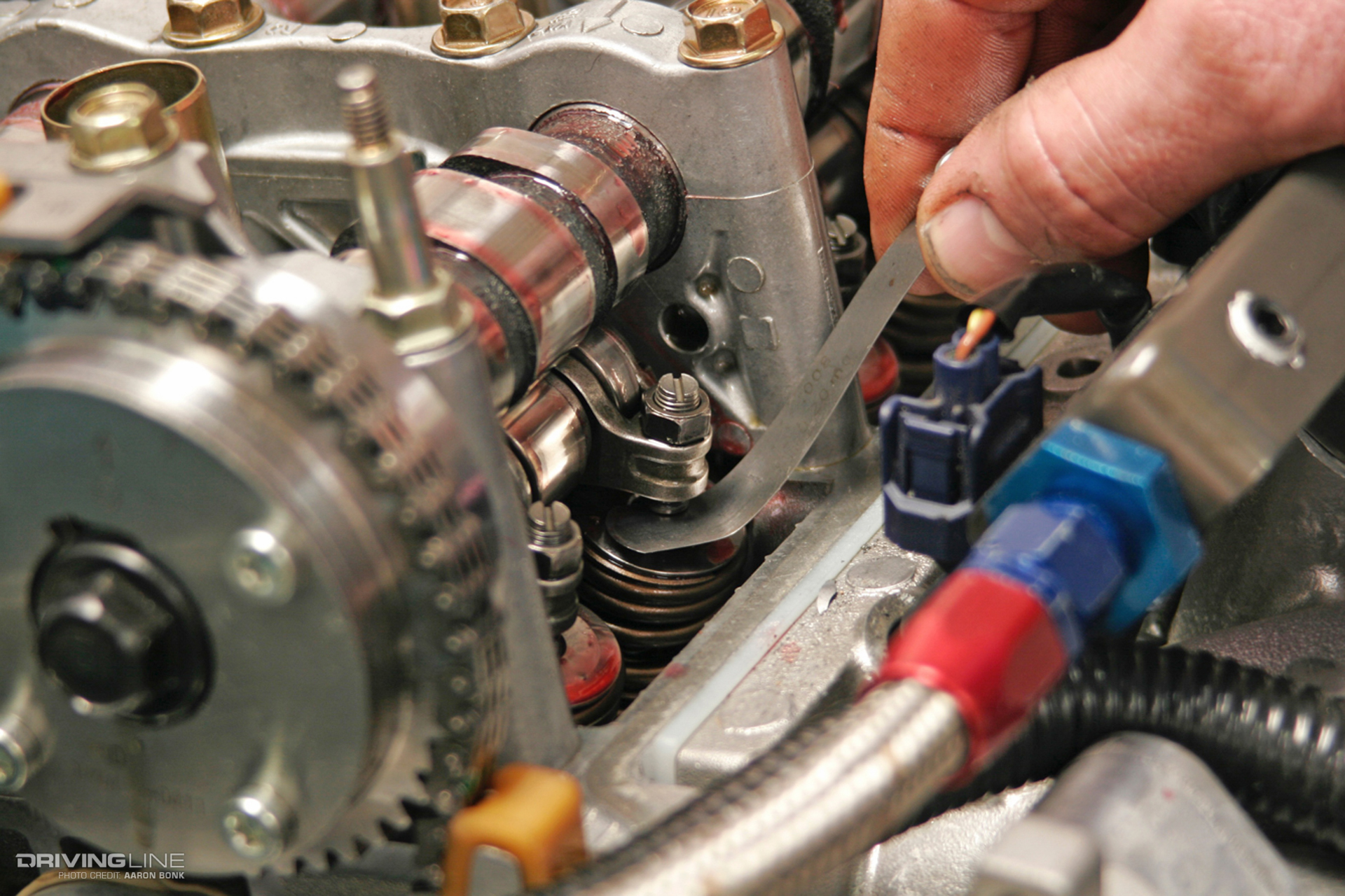 A hand fiddling with a part on an engine