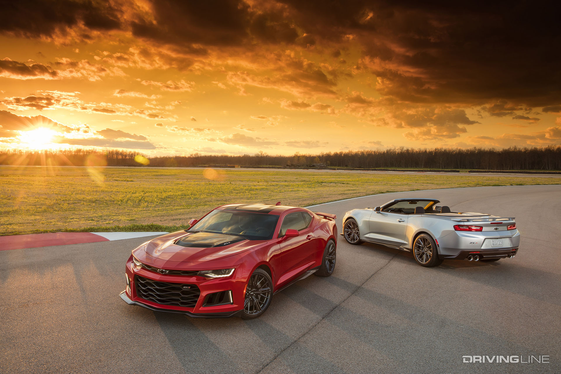 Red and silver Camaro at sunset