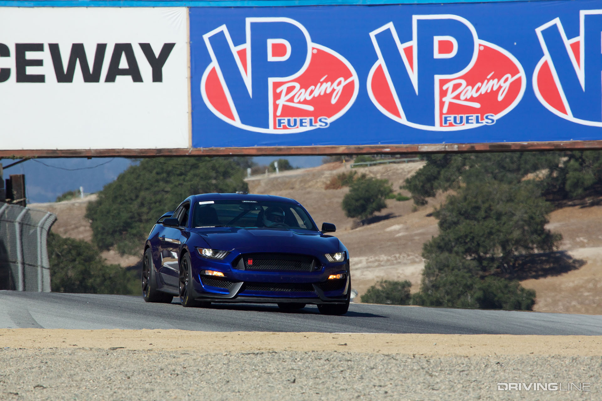 Blue Ford Mustang driving on the racetrack