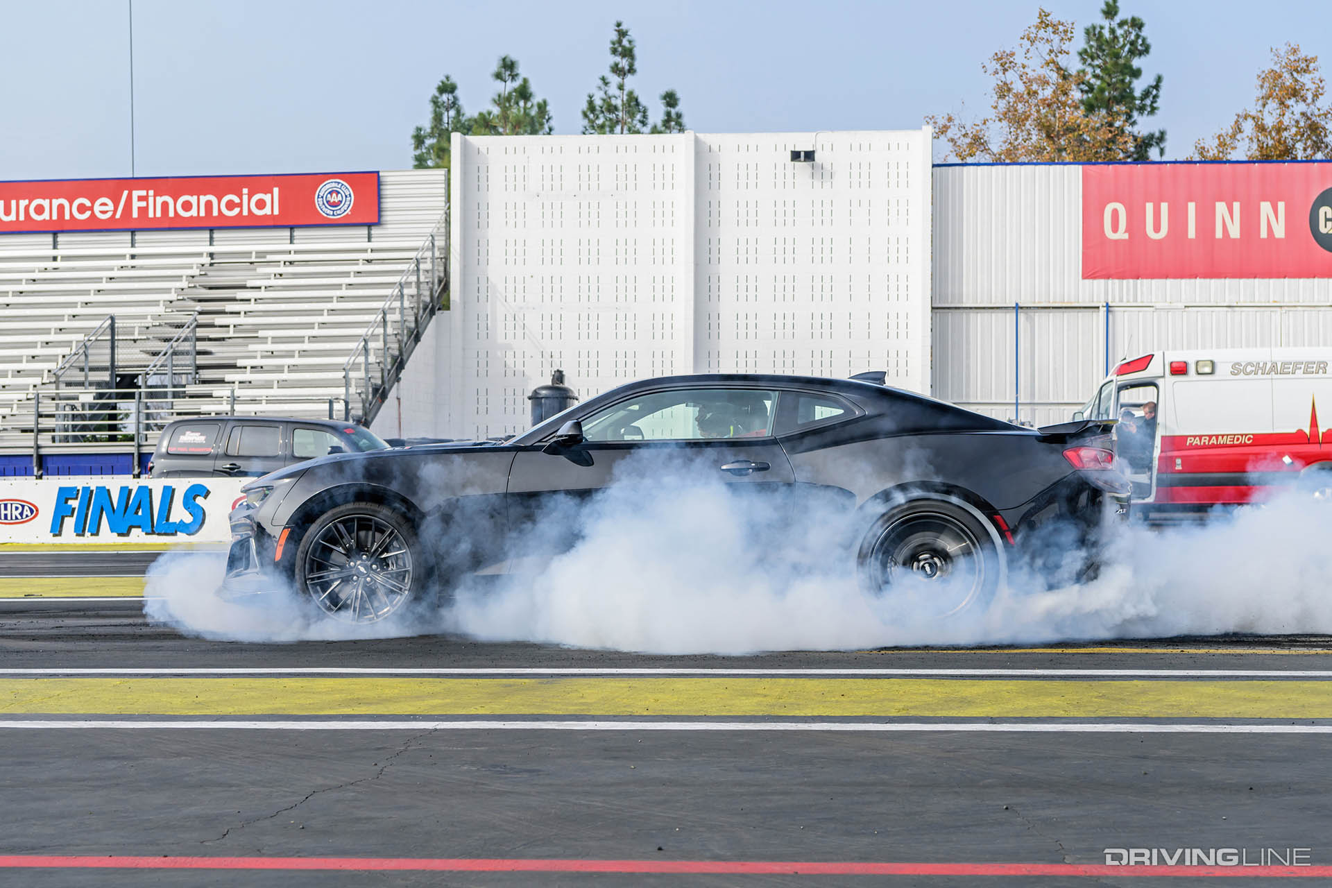 Chevy Camaro doing a burnout on a dragstrip