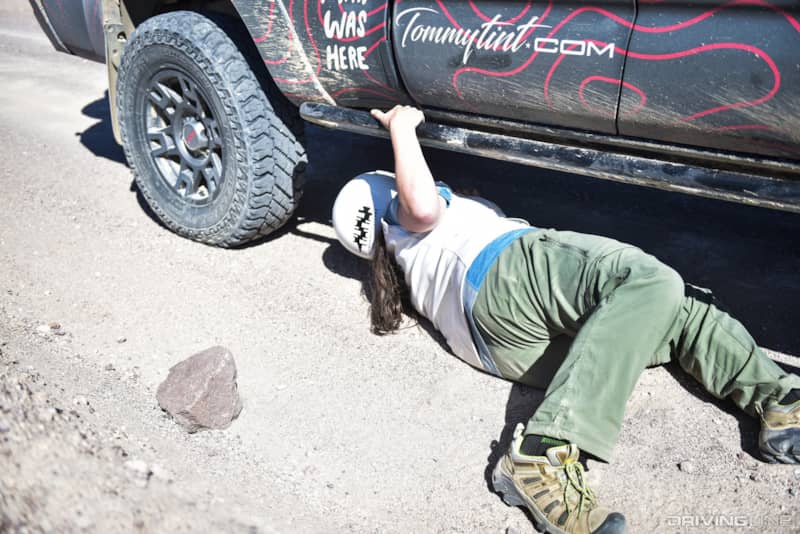 Team Free Range Dames' checking out a potential mechanical issue with their Toyota TRD Tacoma