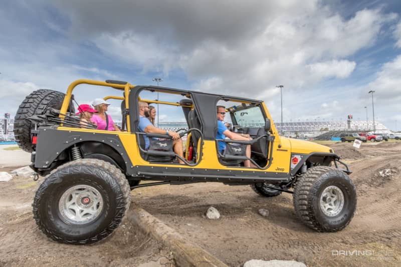 Large, yellow Jeep with a family inside at Jeep Beach