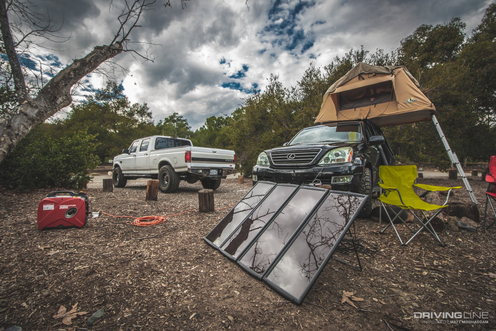 Solar panel and generator in front of a white truck and black Lexus GX470 with a rooftop tent