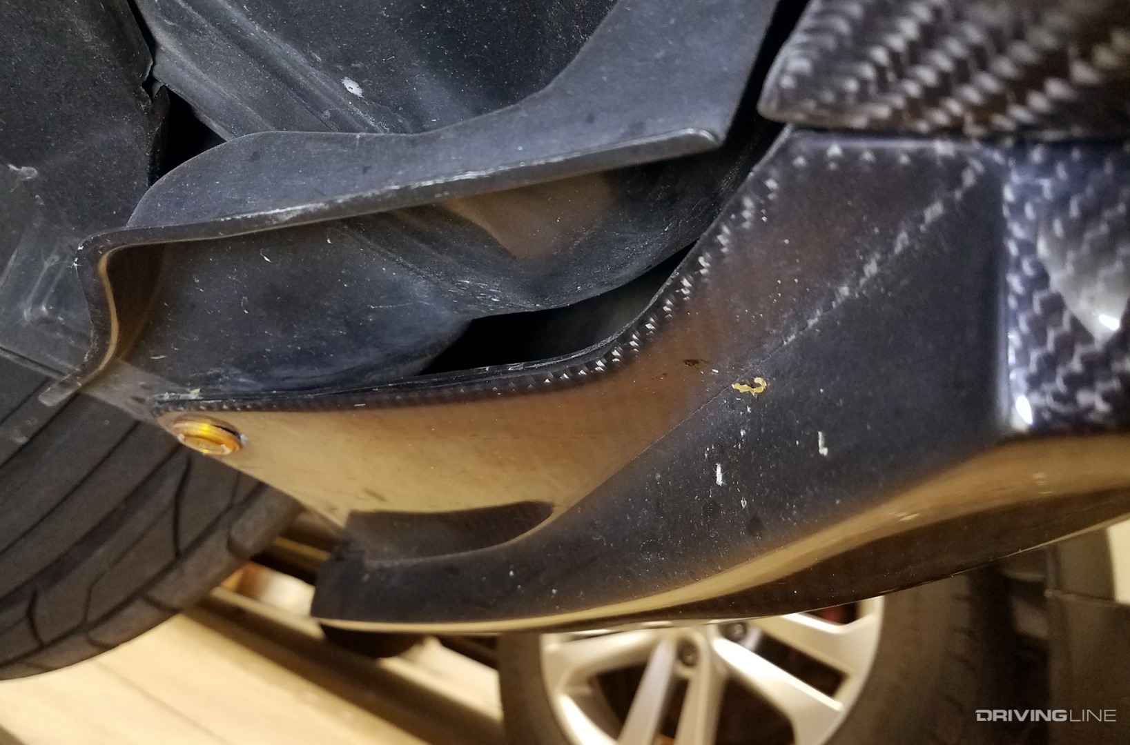 Carbon fiber part with bedliner paint as protection in front of Nitto NT555 G2 tire.