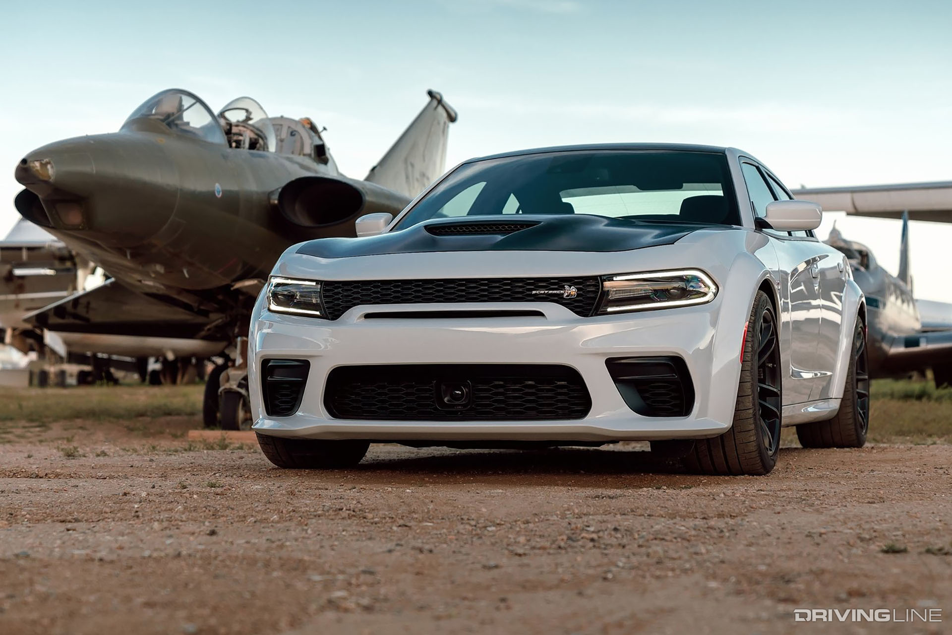 Dodge Charger Scat Pack Widebody in front of a fighter jet