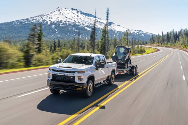 Chevrolet Silverado 2500 towing a trailer with a small earth-mover on it
