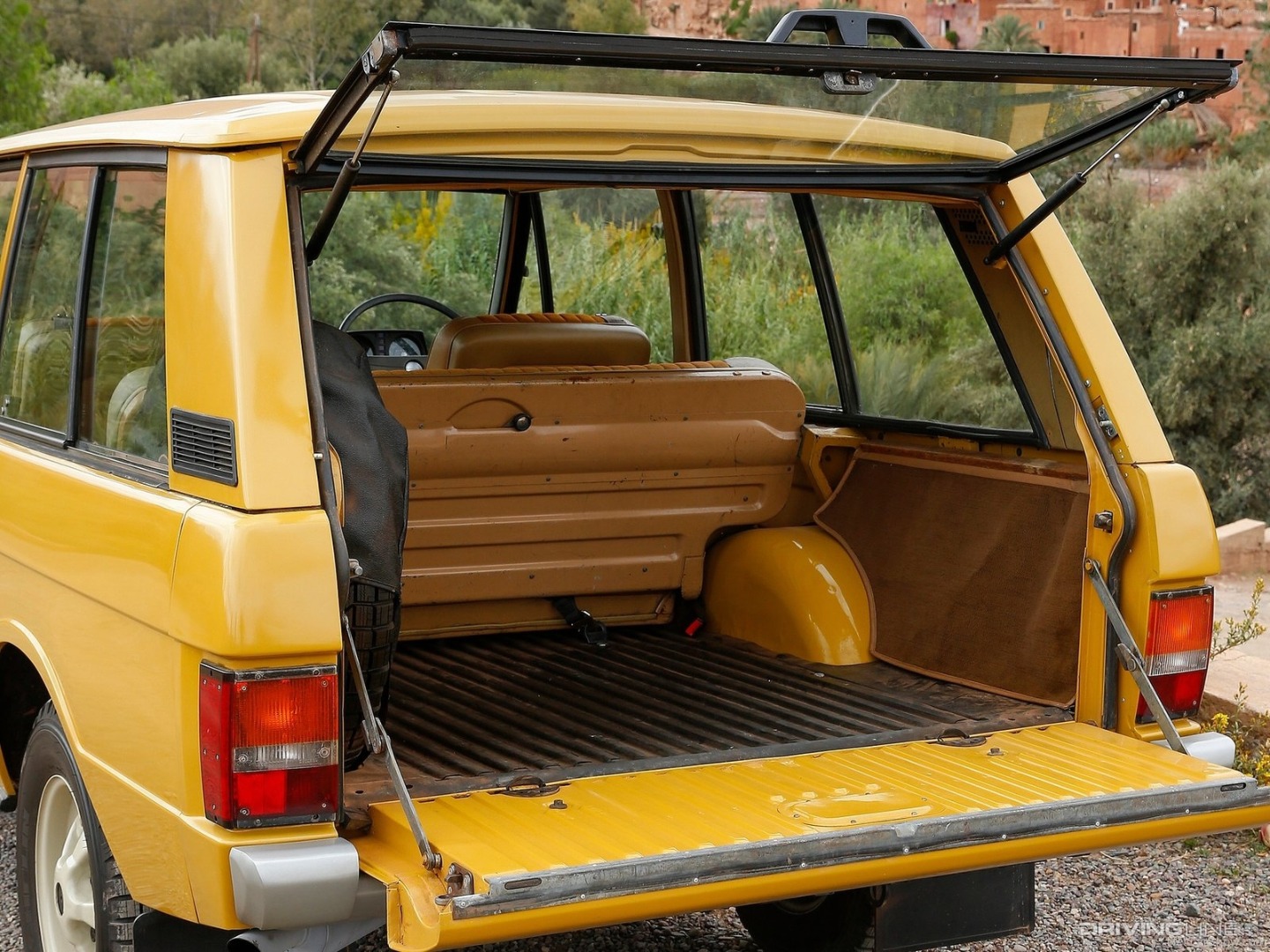 Yellow Land Rover Range Rover Classic cargo area open.