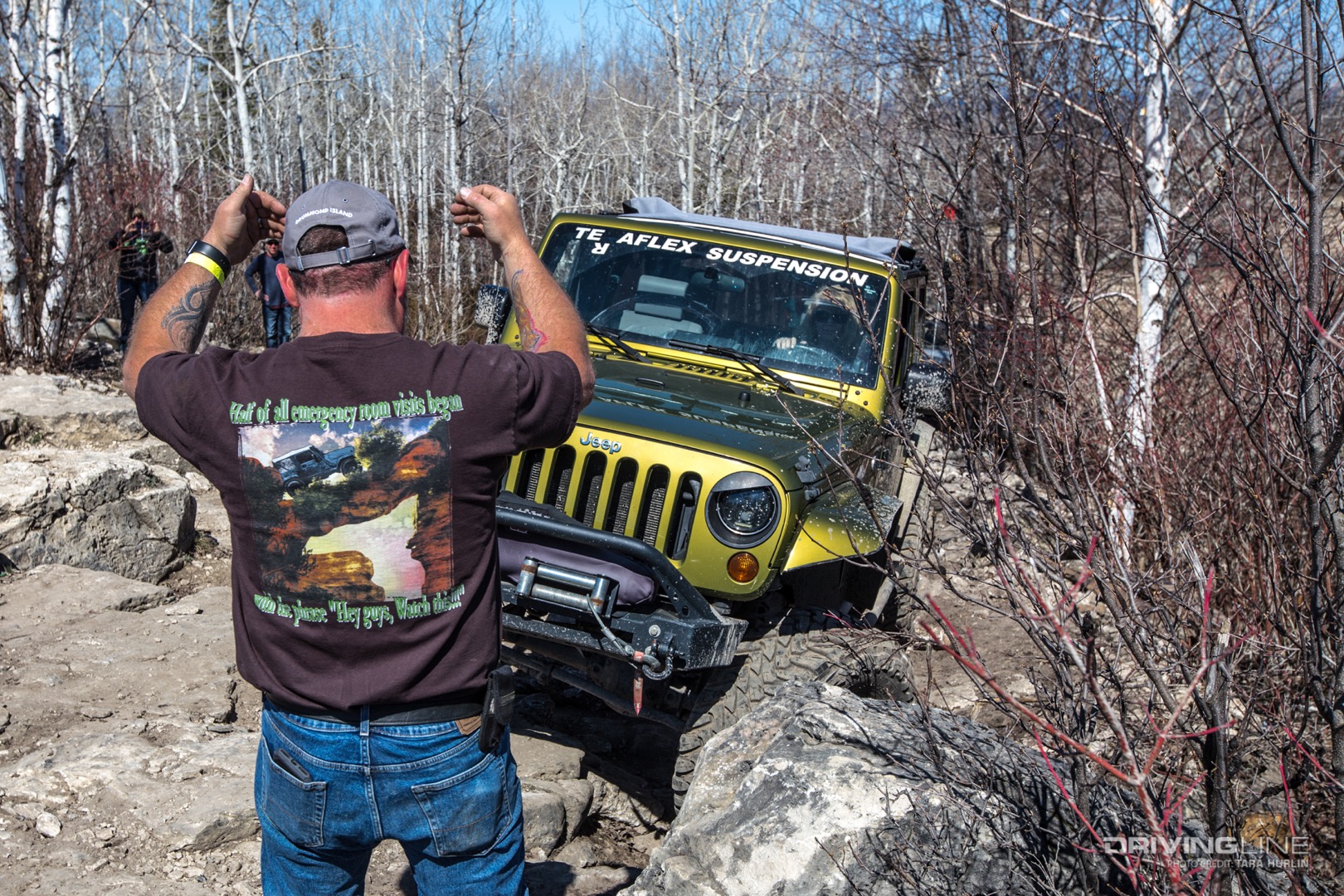 Spotter working to guide a Jeep around obstacles