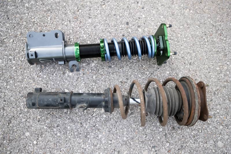 Custom Fortune Auto Coilovers next to OEM Mazda RX-7 shocks.