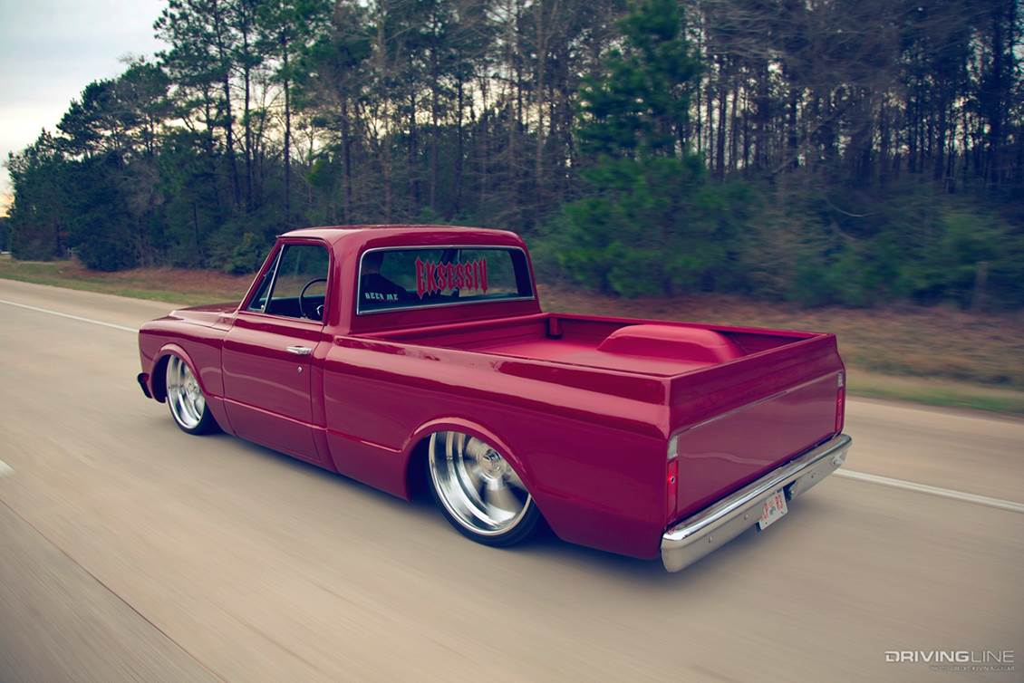 Lowered red pickup driving down highway