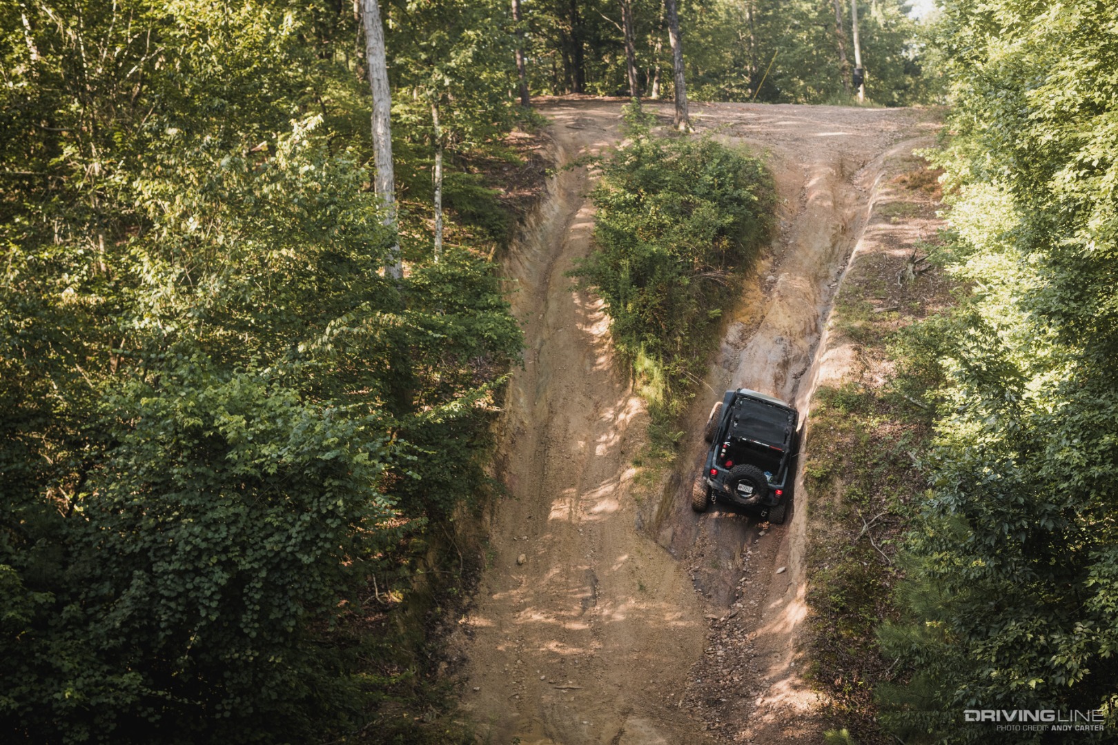 Jeep Wrangler crawls up trail.
