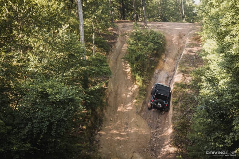 Jeep Wrangler crawls up trail.