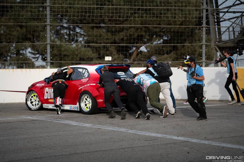 The Papadakis Racing team pushes Ryan Tuerck's car off the track after a collision