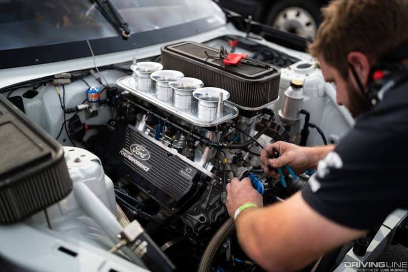 an RTR Team member tracks down a potential mechanical issue with Chelsea Denofa's Ford Mustang RTR