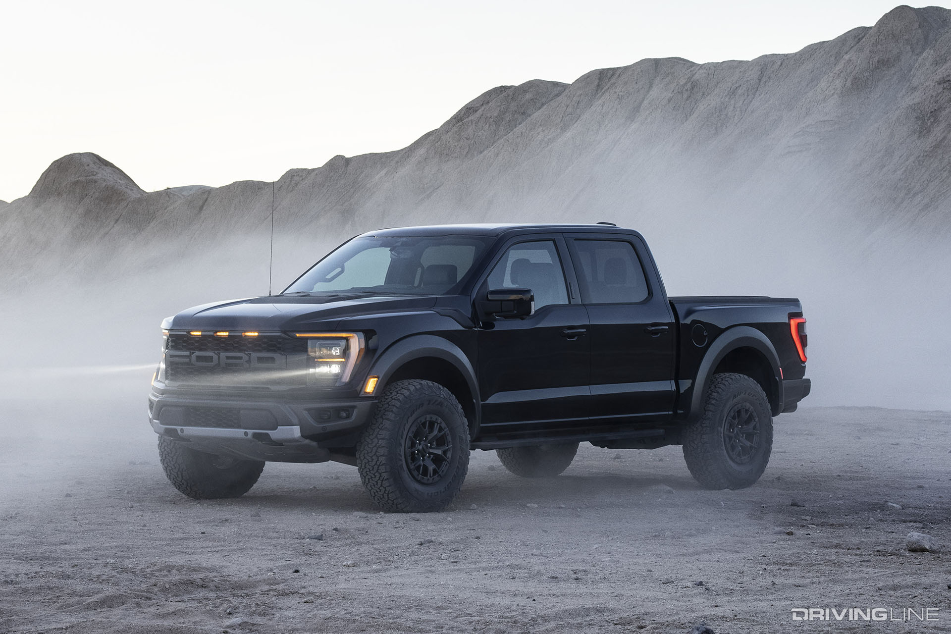 Black 2021 Ford F-150 Raptor with a wall of dirt behind it