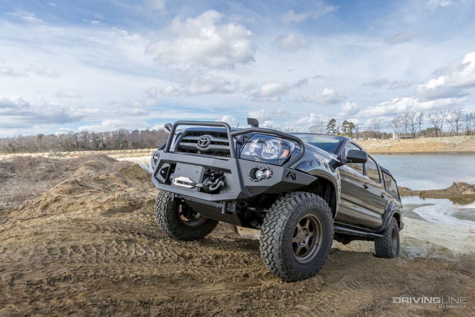Toyota Tacoma on Nittos coming out of mud
