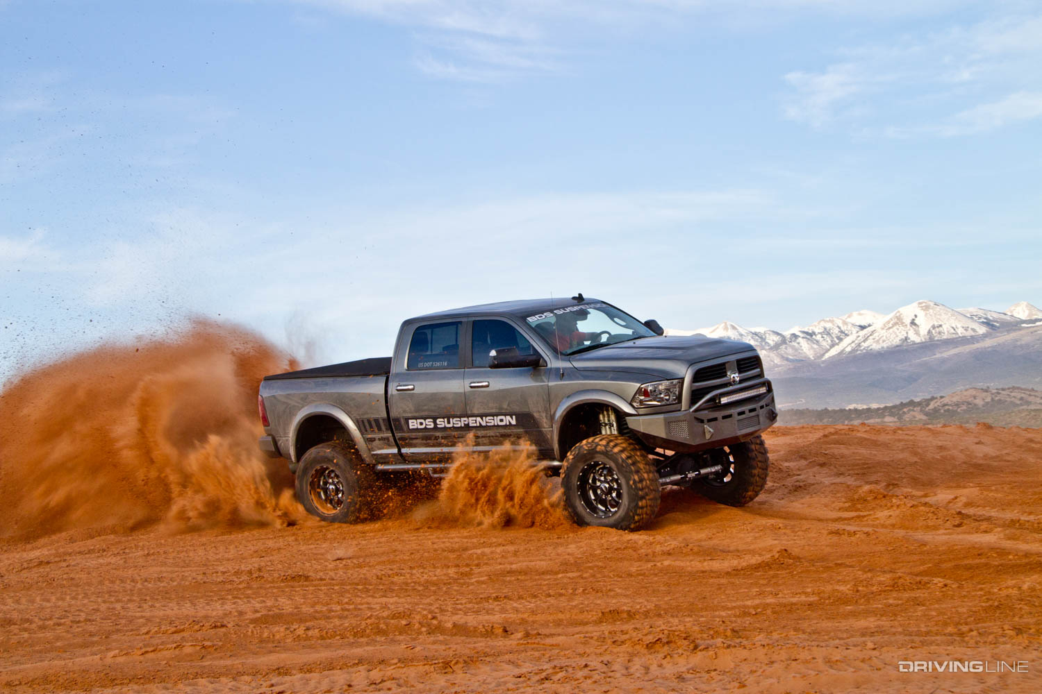 lifted 2013 Ram 3500 on 40" Nitto Mud Grappler Tires driving in Dirt