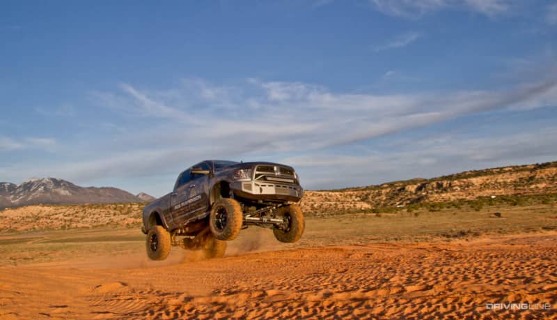 lifted 2013 Ram 3500 on 40" Nitto Mud Grappler Tires jumping in the dirt