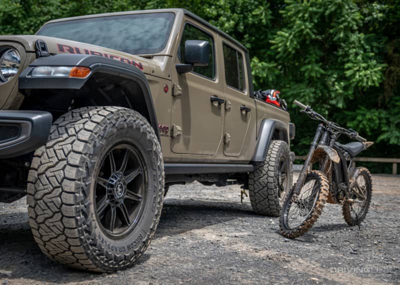 Nitto Recon Grappler all-terrain tires on a Jeep Gladiator next to an electric dirt bike