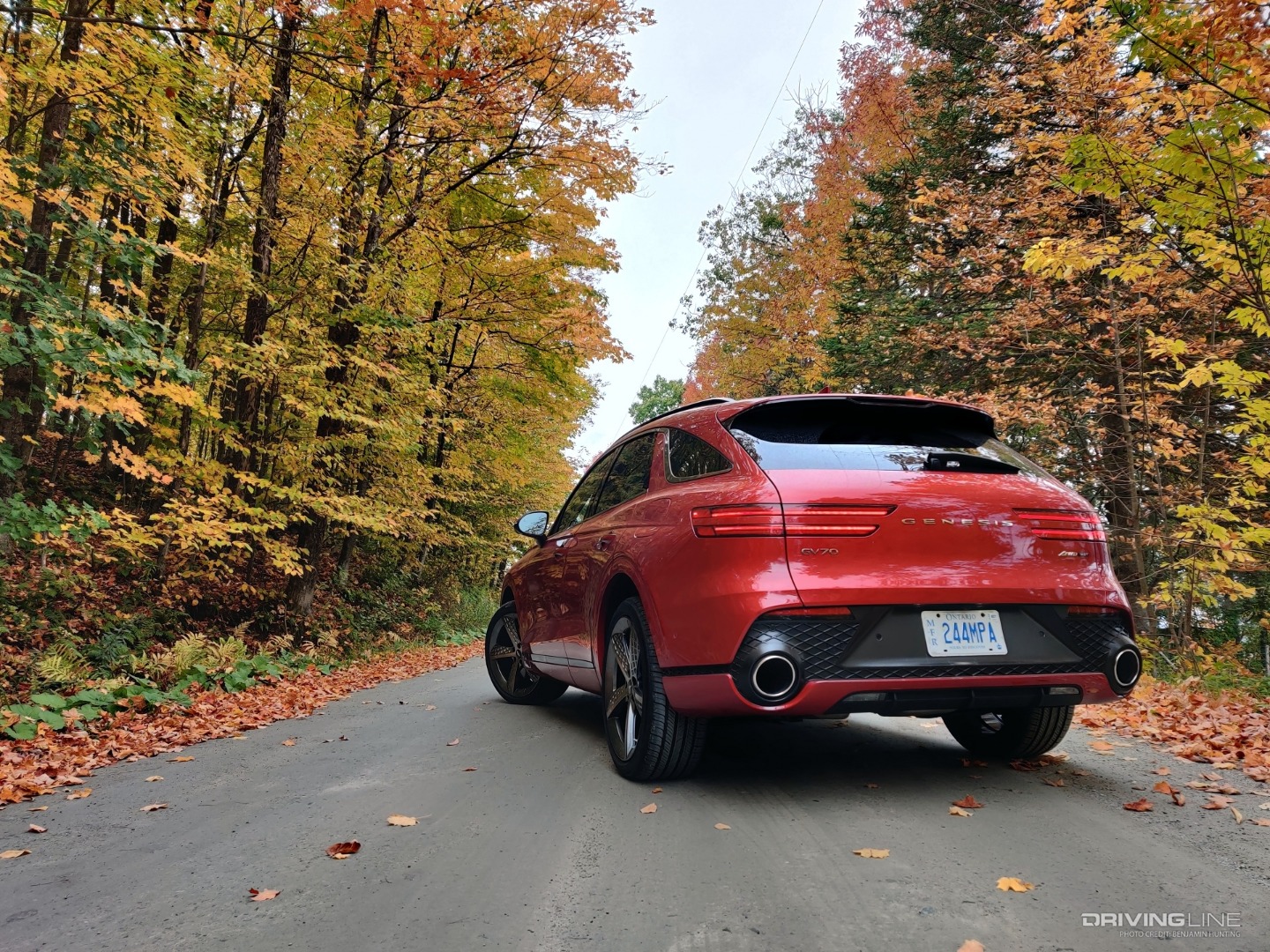 2022 Genesis GV70 on country road with fall leaves from behind