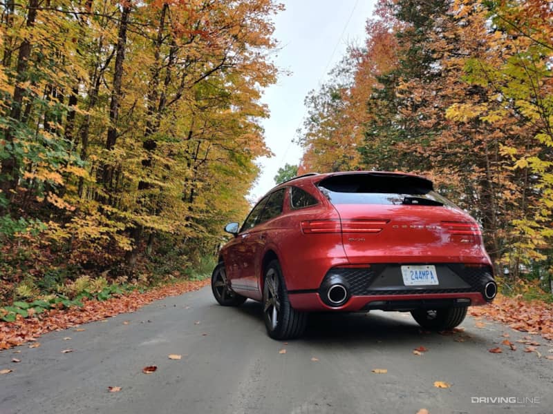 2022 Genesis GV70 on country road with fall leaves from behind