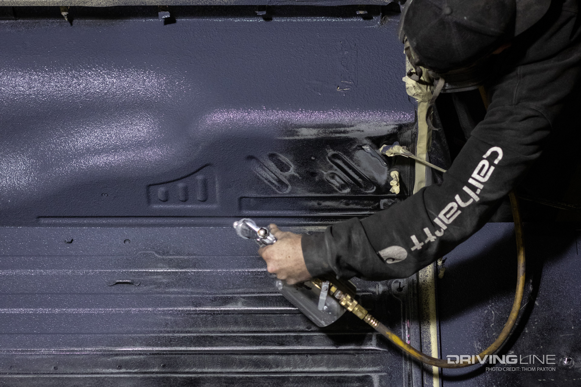 Spraying LizardSkin sound insulation coating on the inside of a Jeep LJ