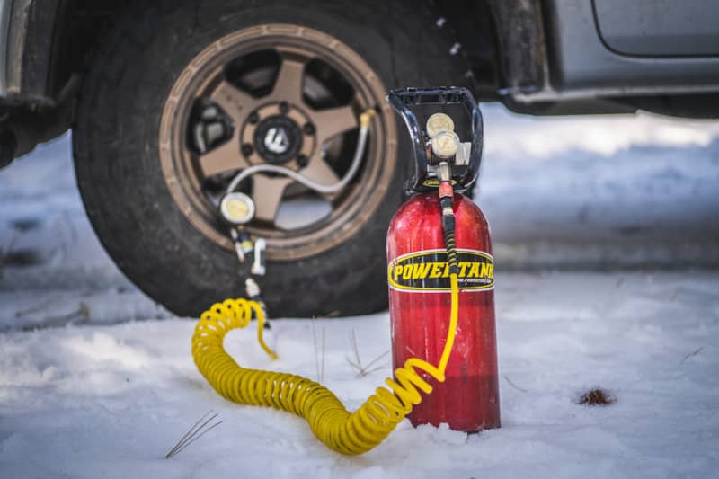 Powertank 10lbs Co2 bottle in front of a tire