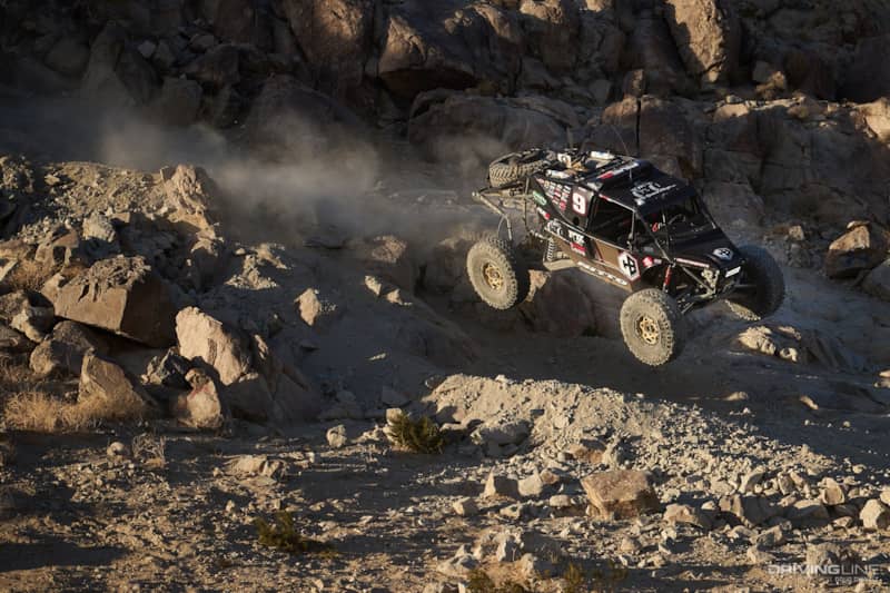Byran Crofts driving off a large rock