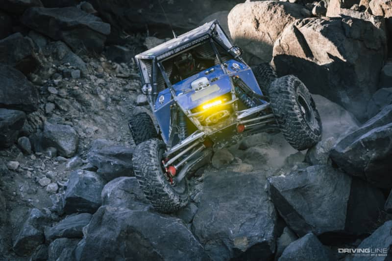 Raul Gomez driving over boulders in the shadow of a canyon