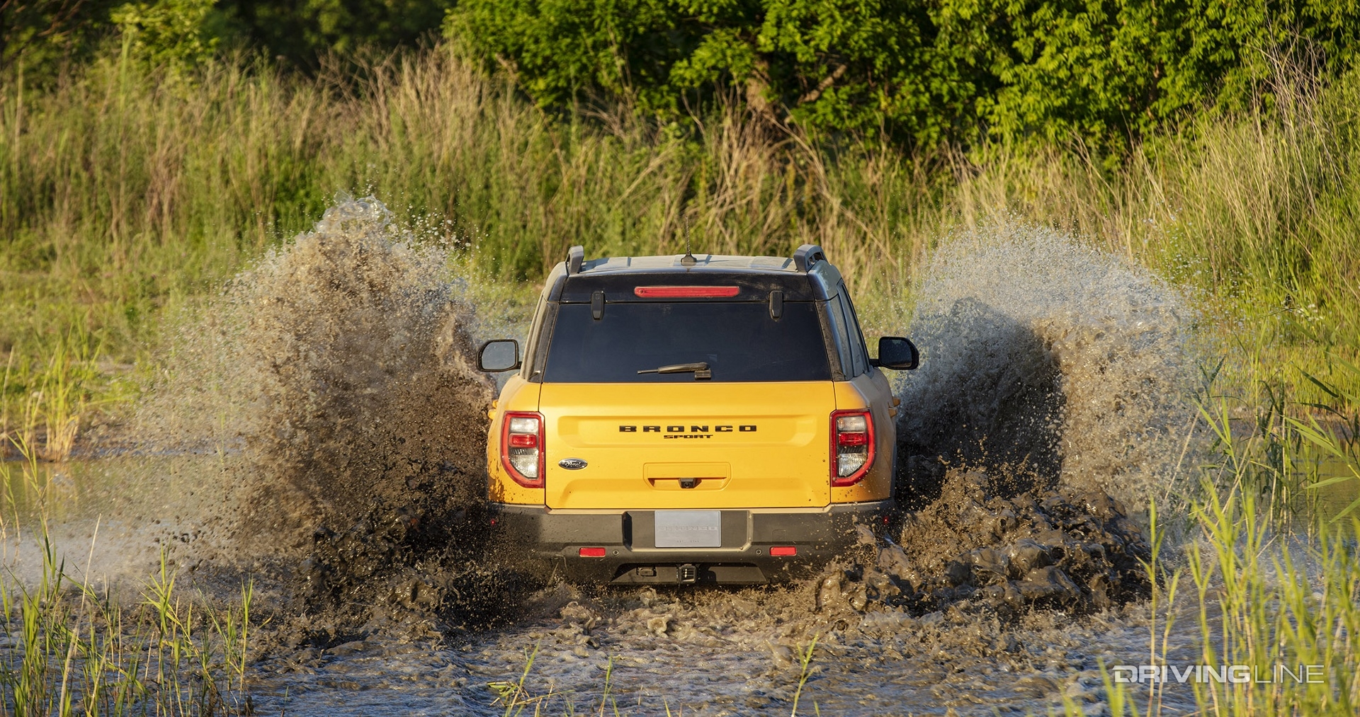 Ford Bronco Sport Badlands yellow from behind in mud