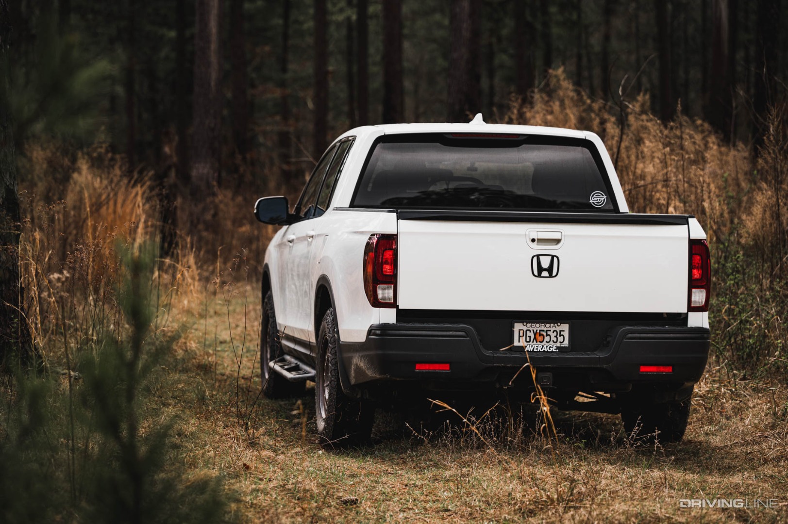Honda Ridgeline on Off-Road Trail from the rear near tall grass