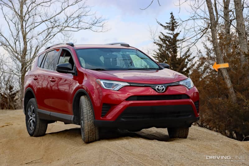 RAV4 on a sand dune next to trees