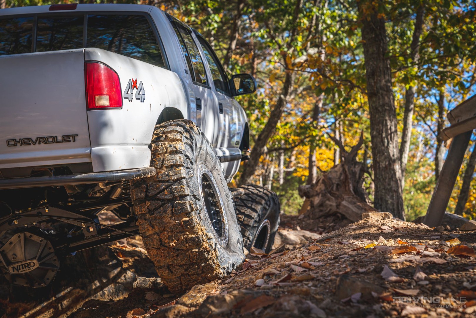 nitto tire mud grapplerflexing on chevy truck in forest off-road