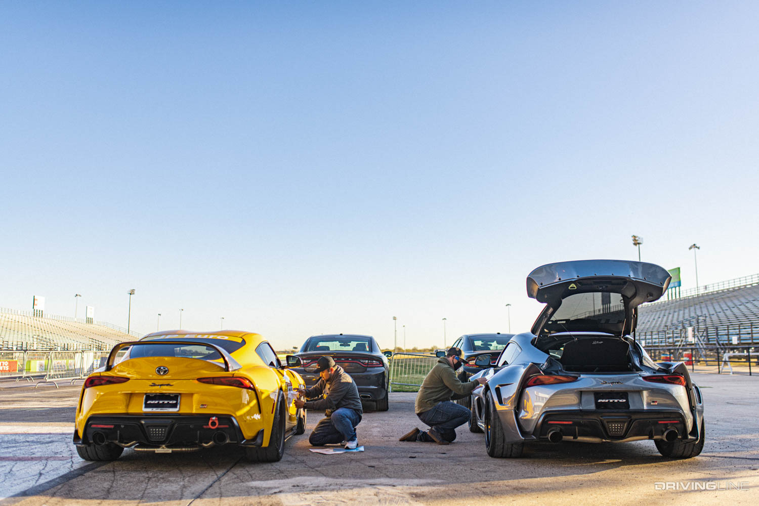 Two Toyota GR Supras at drag strip track, both on Nitto NT555 RII drag radials
