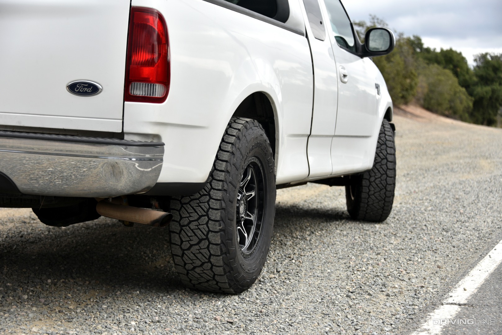 Nitto Recon Grappler all-terrain tires tread detail on Passenger side of white 2000 Ford F-150