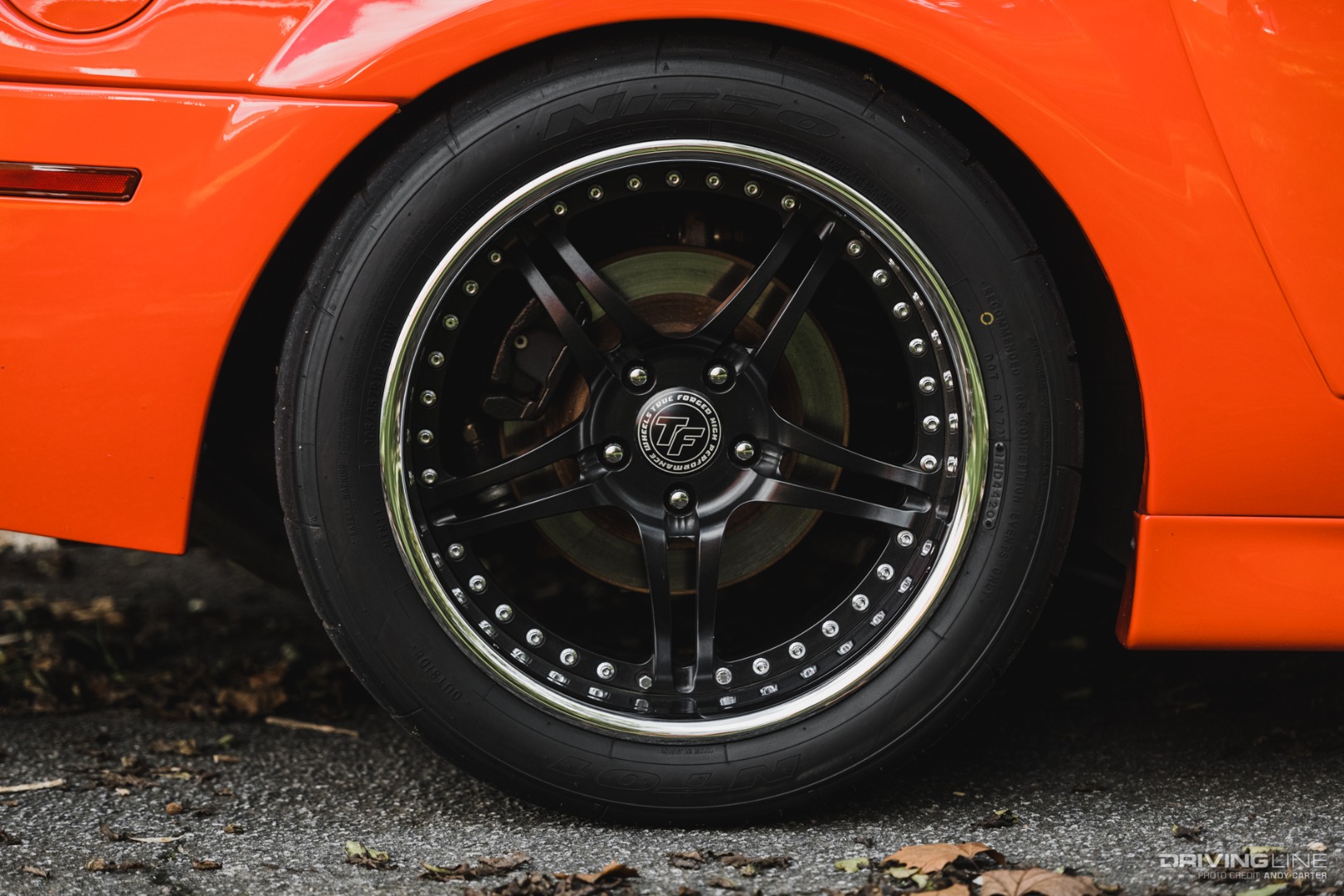 Forged wheel and Nitto NT01 tire on orange Mustang close-up rear