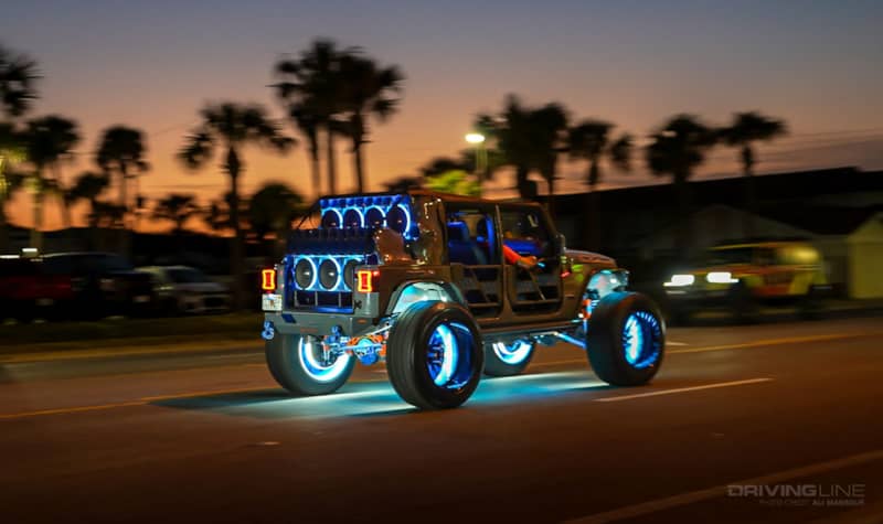 Jeep Gladiator with neon speakers driving at night in Daytona Beach