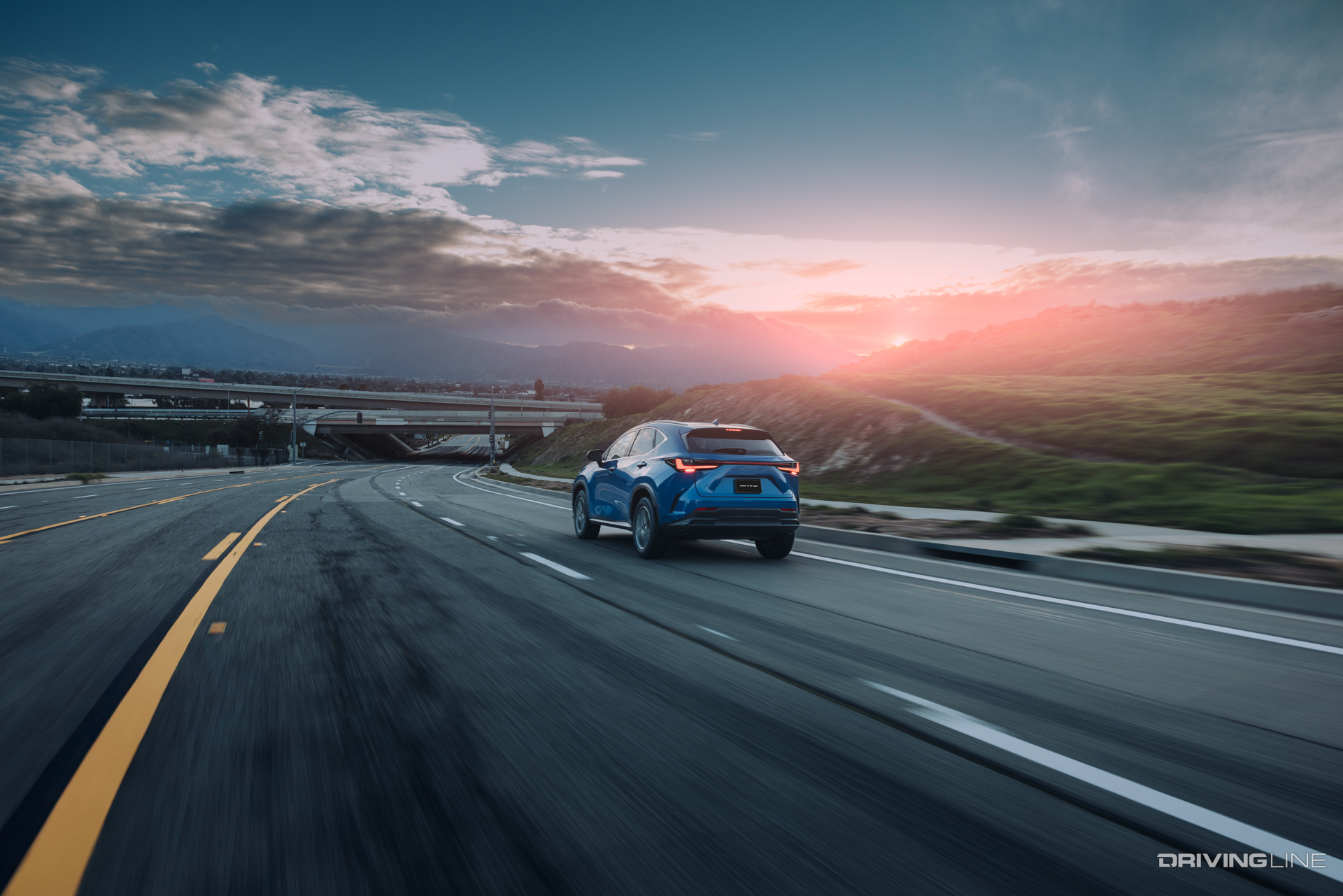 Blue CUV driving into sunset and clouds on Nitto Motivo 365 all season tire