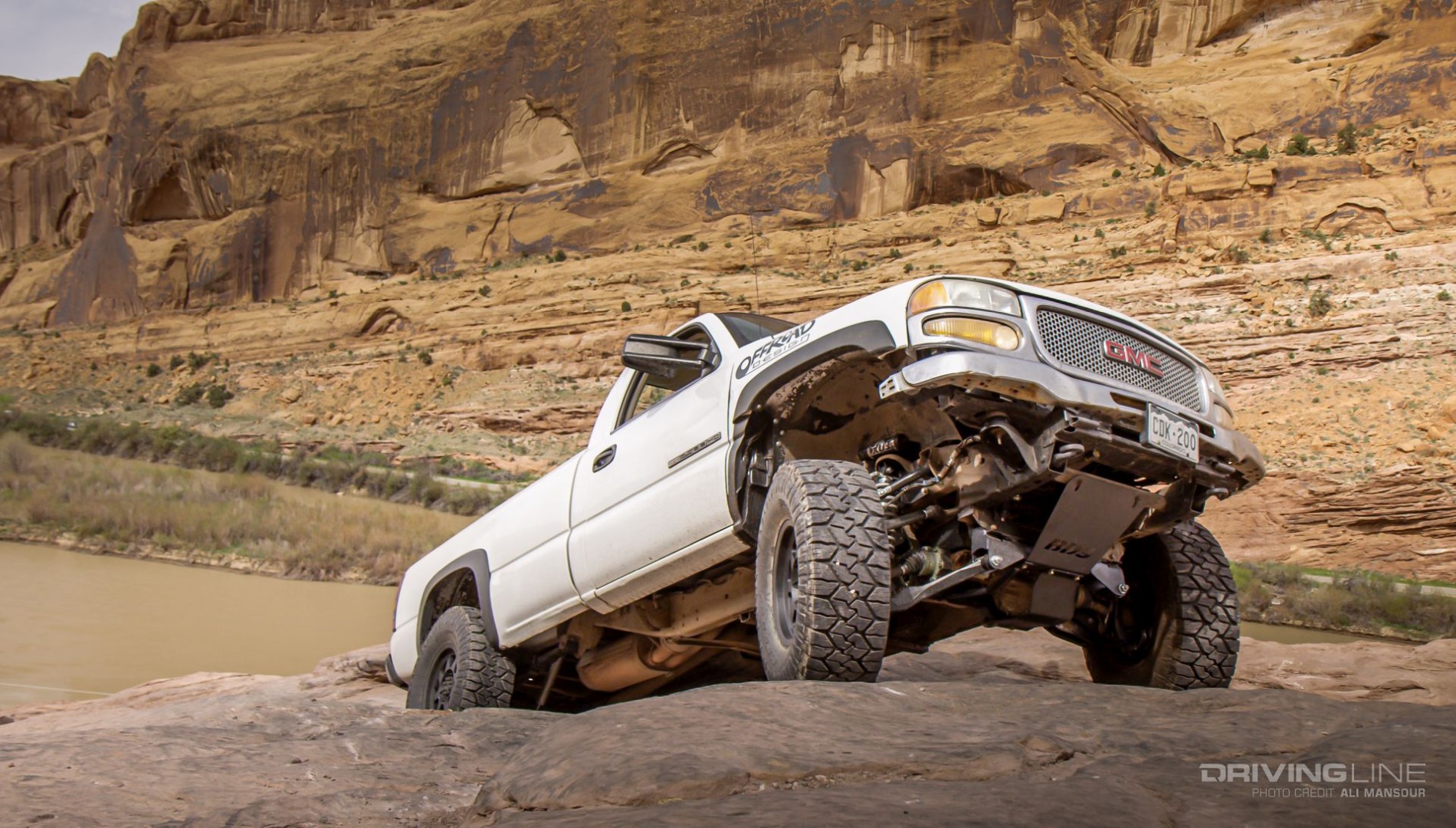 Full-size off-road pickup GMC climbing rock face