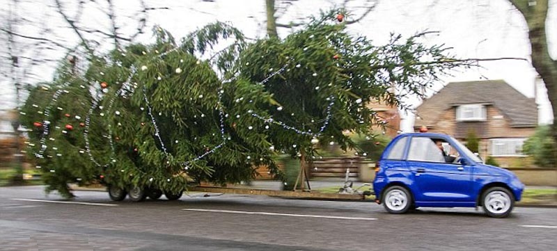 electric car towing a giant Christmas tree