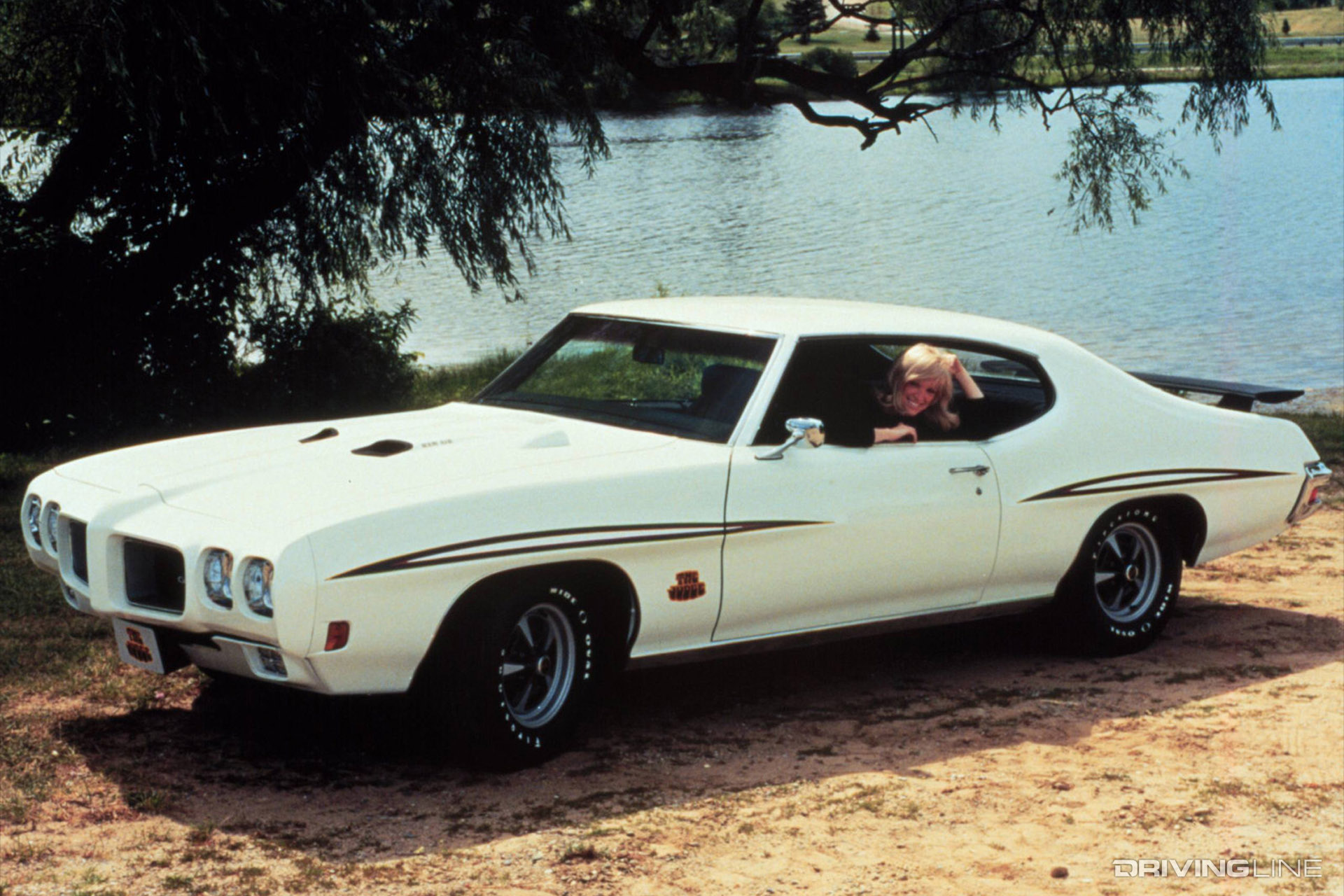 White 1970 Pontiac GTO with a woman in the driver's seat