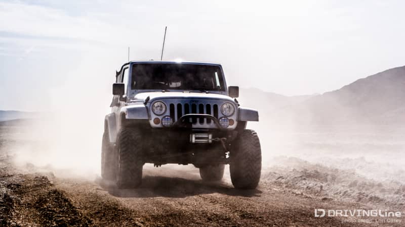 Jeep Wranlger kicking up dust on a trail