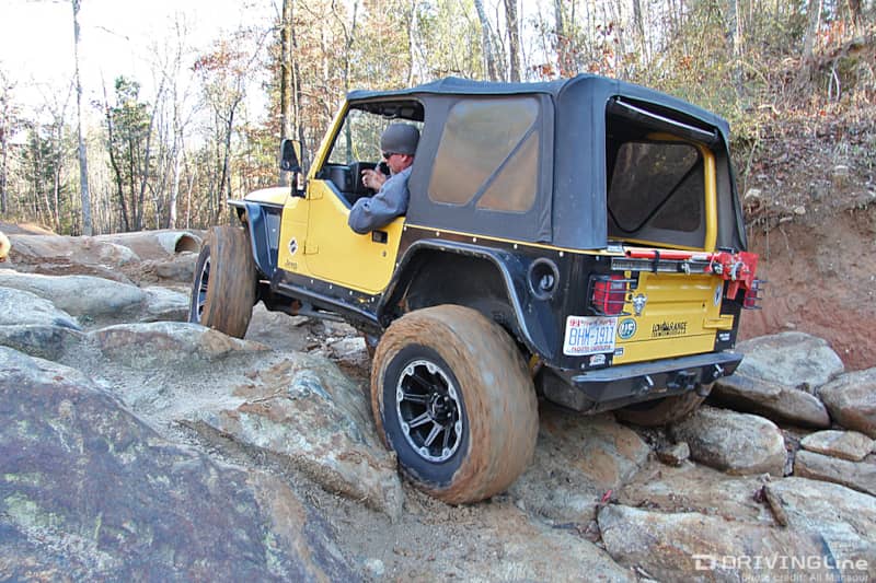 Jeep Wrangler TJ with a soft top rock crawling on a trail