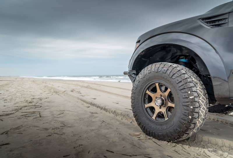 35 Nitto Ridge Grappler tires on a Bronze wheel Ford Raptor beach