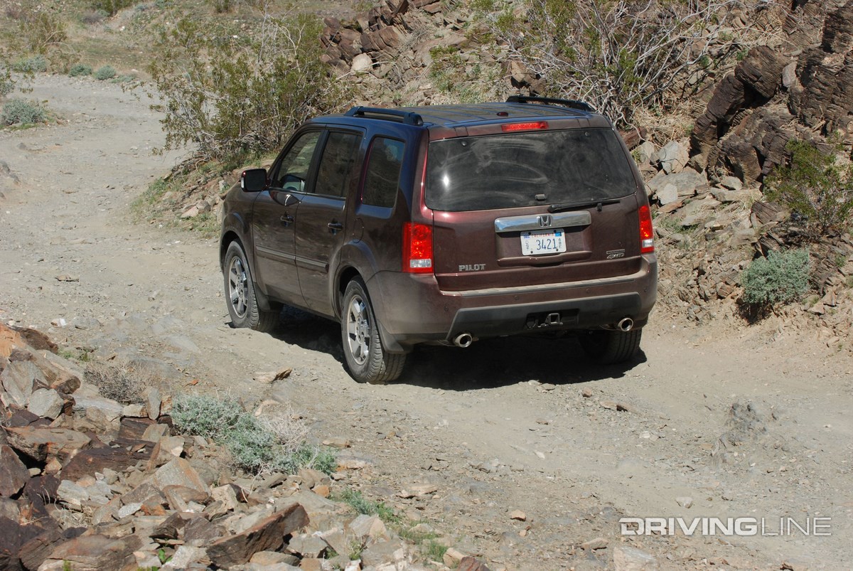 Honda Pilot on off-road trail from behind