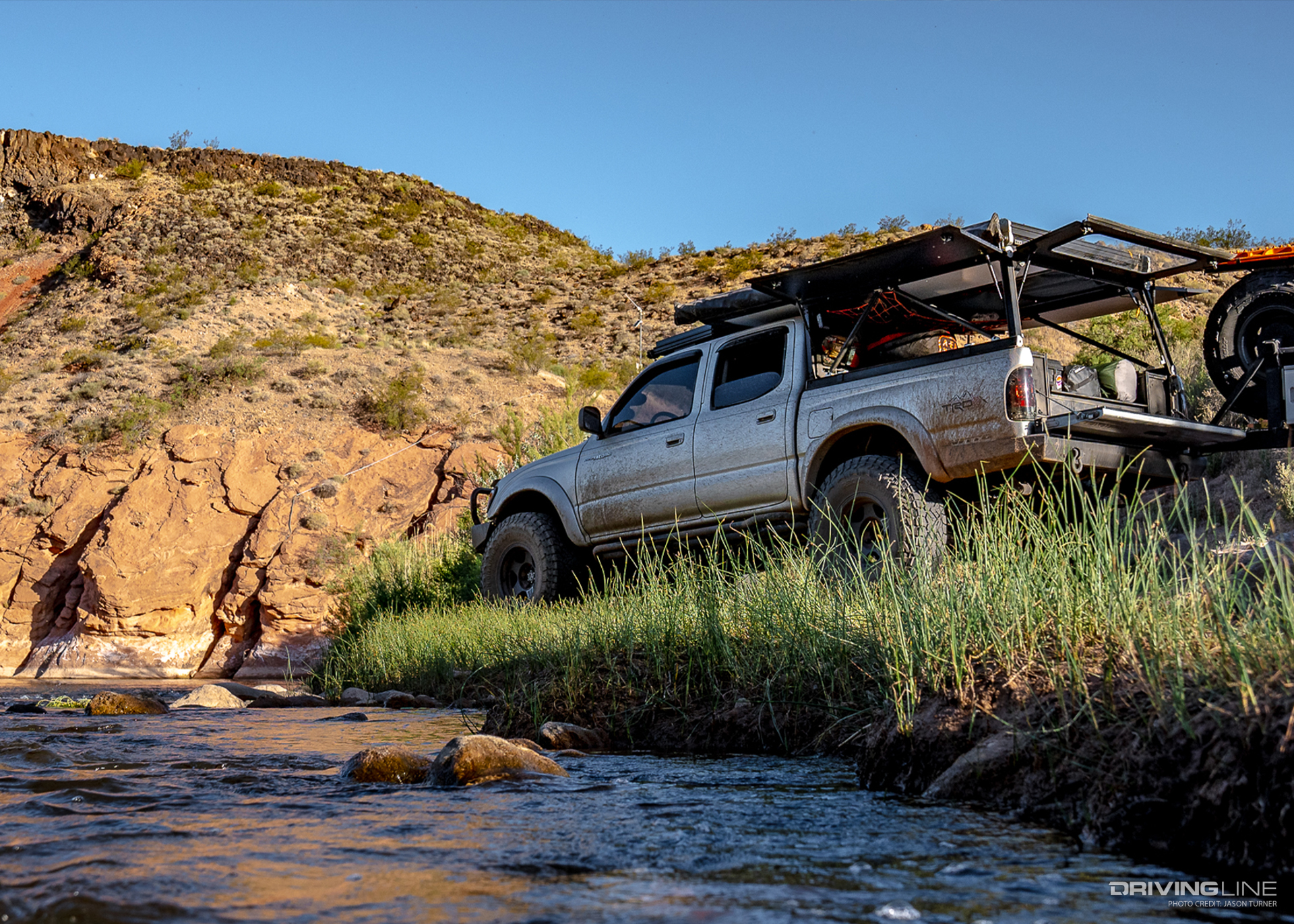 Toyota Tacoma Go Rig overlanding next to stream