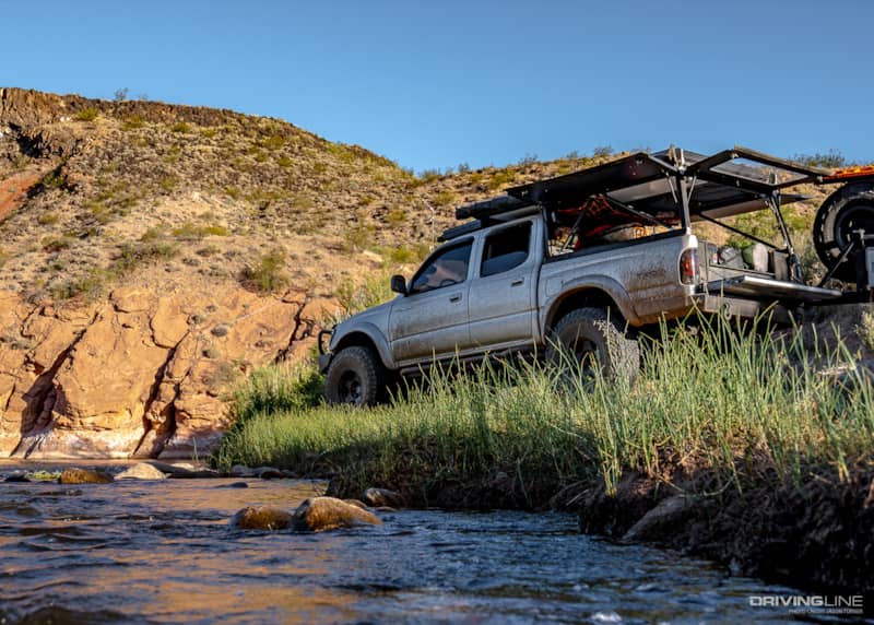 Toyota Tacoma Go Rig overlanding next to stream