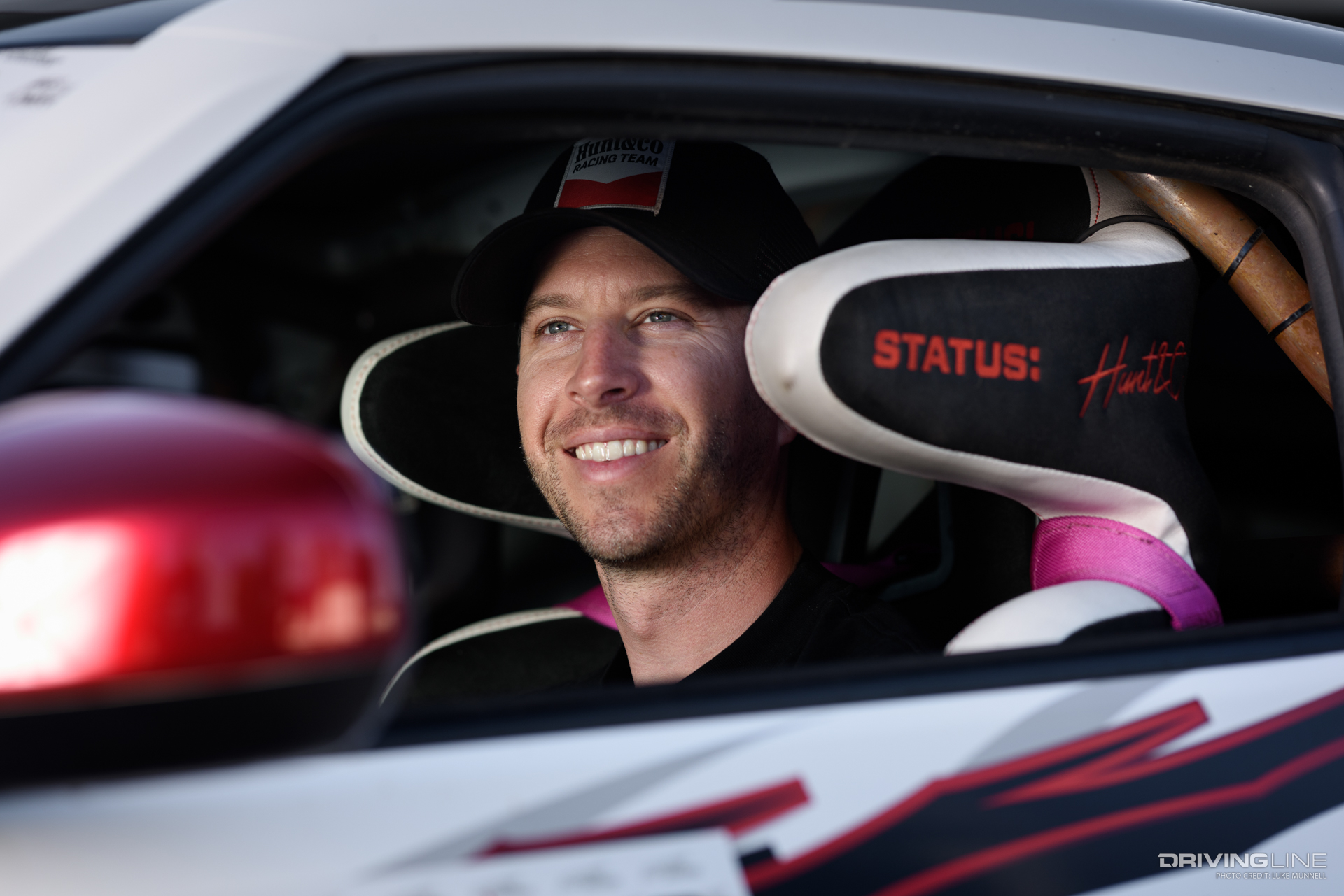 TJ Hunt smiling in the driver seat of his white Nissan Z drift car